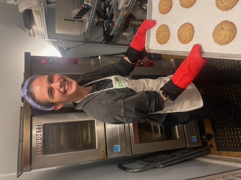 A baker holding the cookies they made