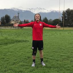 Shea Hammond standing on a soccer field with arms open