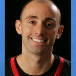 Image of MIke Simmel. The image is of a bald man, with a big smile. He is wearing a black shirt with red trim.
