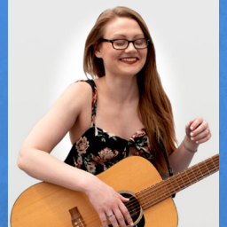 Image of a teenage girl with light brown hair, a floral tank blouse. She is wearing glasses, smiling, and her eyes are closed from excitement. She is holding a guitar. The background is white.