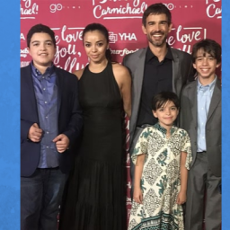 Image of Chris Gorham and his family of five, two boys and one girl. They are standing on a red-carpet event with a red poster with words behind them. Chris (right) and his wife, Anel (left), are the the middle of the photo. Lucas has Asperger's Syndrome and stand to the left of his mom in the photo Chris beside his other son who is to the right of the picture. Thei daughter is standing in front of Chris. The Anel is of Mexican descent and Chris is white. Their children are biological in nature.