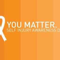 Image of a gradient orange sign with the words "YOU MATTER SELF INJURY AWARENESS DAY" and a white ribbon. 