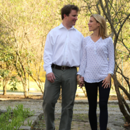 Allison Pataki and Dave Levy walking in a tree lined park holding hands.
