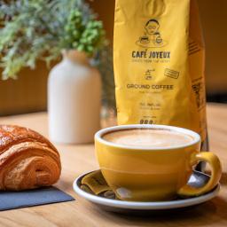 A picture of a latte in front of a bag of coffee