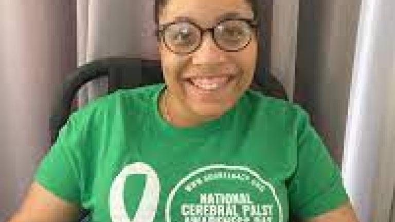 Tylia Flores in a green t-shirt marked with National Cerebral Palsy Awareness Day Logo.
