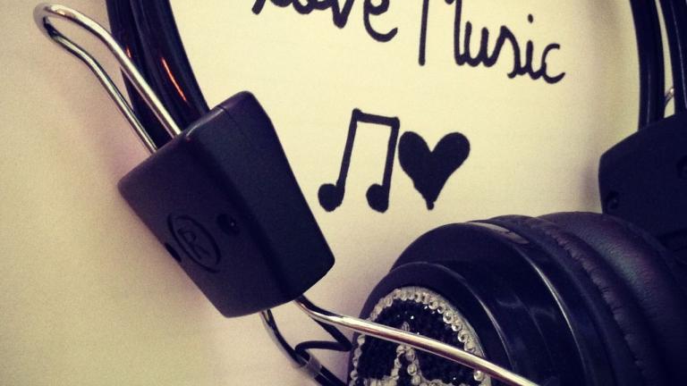 Recording headphones over script on table that reads "love Music"